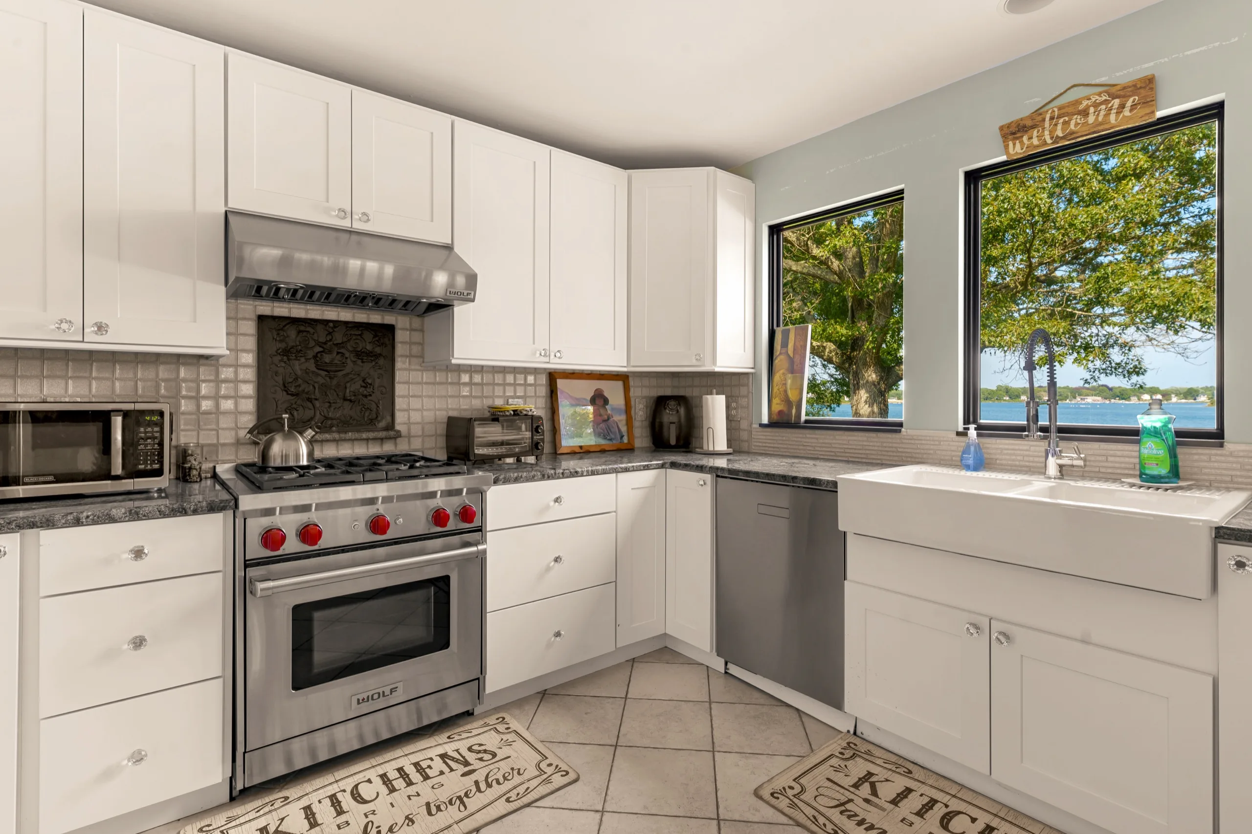 Shaker kitchen with farmhouse sink and a window looking straight out over the water